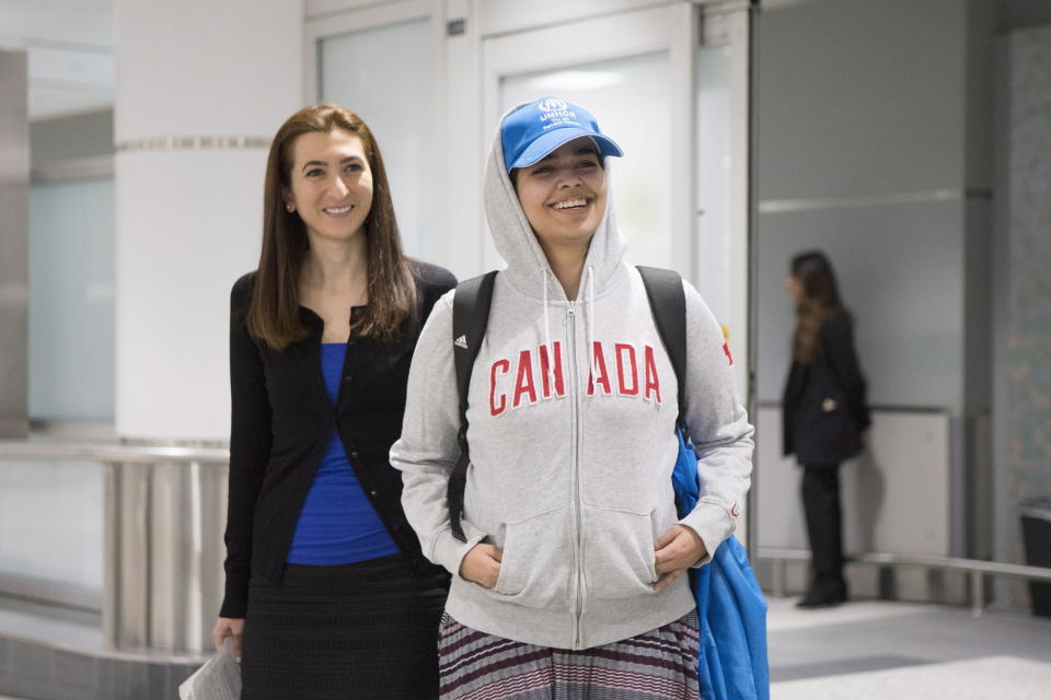 Rahaf Mohammed Alqunun, de 18 años, centro, con Saba Abbas, de Servicios Inmigratorios COSTI, al llegar al aeropuerto internacional Pearson de Toronto el sábado 12 de enero de 2019. (Chris Young/The Canadian Press vía AP)