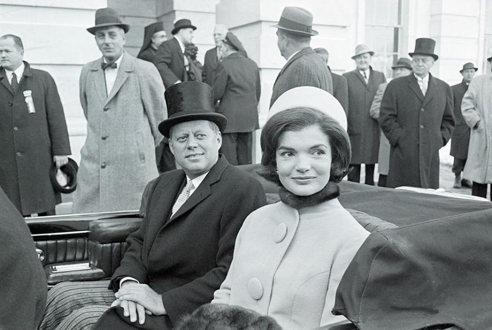 <p>The President and First Lady leave the Capitol following his swearing-in ceremony to become the 35th President of the United States. Jackie wears a coat with mod oversize buttons, and the cloth pillbox hat (designed by Halston) set a new tone for the young couple of the White House.<br></p>