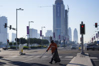 A municipal worker walks in a street in Doha downtown, Qatar, Thursday, Nov. 24, 2022. (AP Photo/Pavel Golovkin)