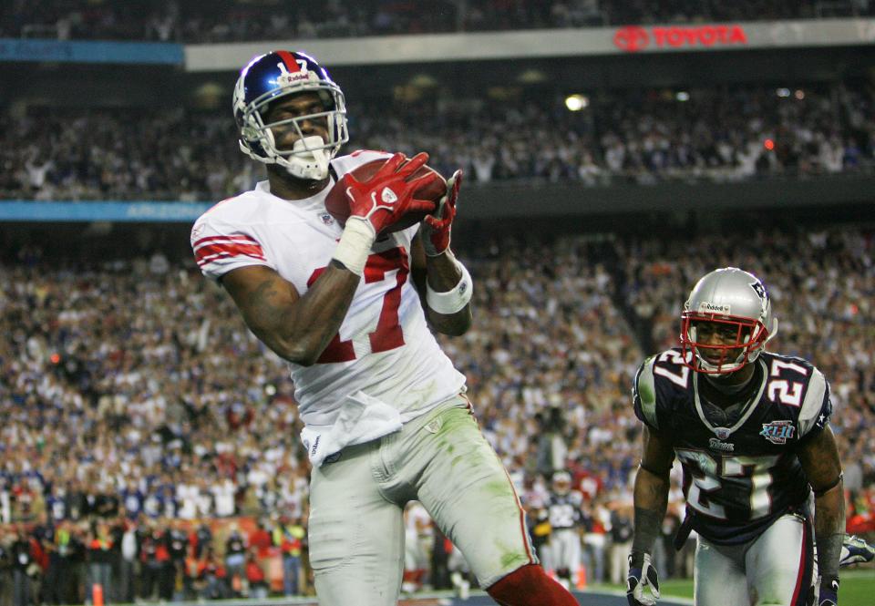 Wide receiver Plaxico Burress of the Giants catches a 13-yard touchdown pass in the fourth quarter over Ellis Hobbs of the New England Patriots during Super Bowl XLII.