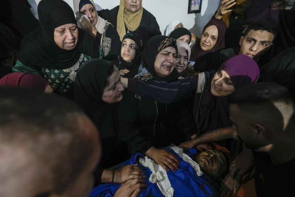 Family of Palestinian militant Samer El Shafei mourn over his body in the Nur Shams refugee camp near the city of Tulkarem, in the occupied West Bank Saturday, May 6, 2023. Israeli forces shot dead two Palestinians during a military raid in the occupied West Bank Saturday, the Palestinian Health Ministry said, while a local armed group said the pair were militants.The ministry and Tulkarem's branch of Al Aqsa Martyrs Brigades, a militant group with connections to President Mahmoud Abbas' Fatah party, identified the pair as Samer El Shafei and Hamza Kharyoush, both aged 22 years. (AP Photo/Majdi Mohammed)