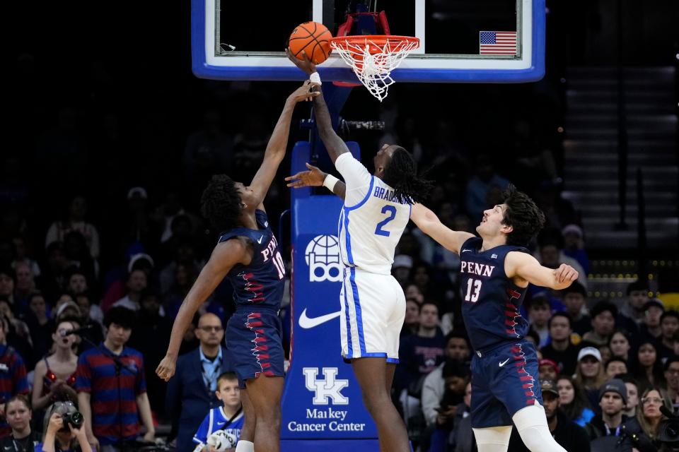 Kentucky's Aaron Bradshaw, center, goes up for a shot against Pennsylvania's Eddie Holland III, left, and Nick Spinoso during the first half of an NCAA college basketball game, Saturday, Dec. 9, 2023, in Philadelphia.