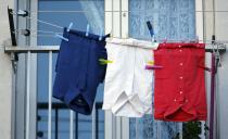 Blue, white and red shirts, the colours of the French national flag, hang from a balcony in Marseille, France, November 27, 2015 as the French President called on all French citizens to hang the tricolour national flag from their windows on Friday to pay tribute to the victims of the Paris attacks during a national day of homage. (REUTERS/Jean-Paul Pelissier)