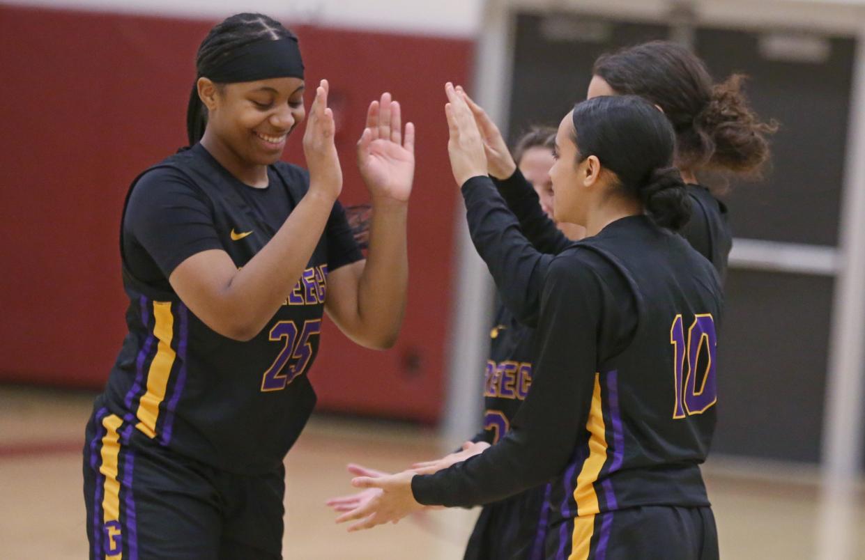Greece Athena/Odyssey's Trinity Johnson (25), left, high-fives her teammates during player introductions before taking on Pittsford Mendon during their Section V girls basketball matchup Monday, Dec. 19, 2022 at Pittsford Mendon High School.