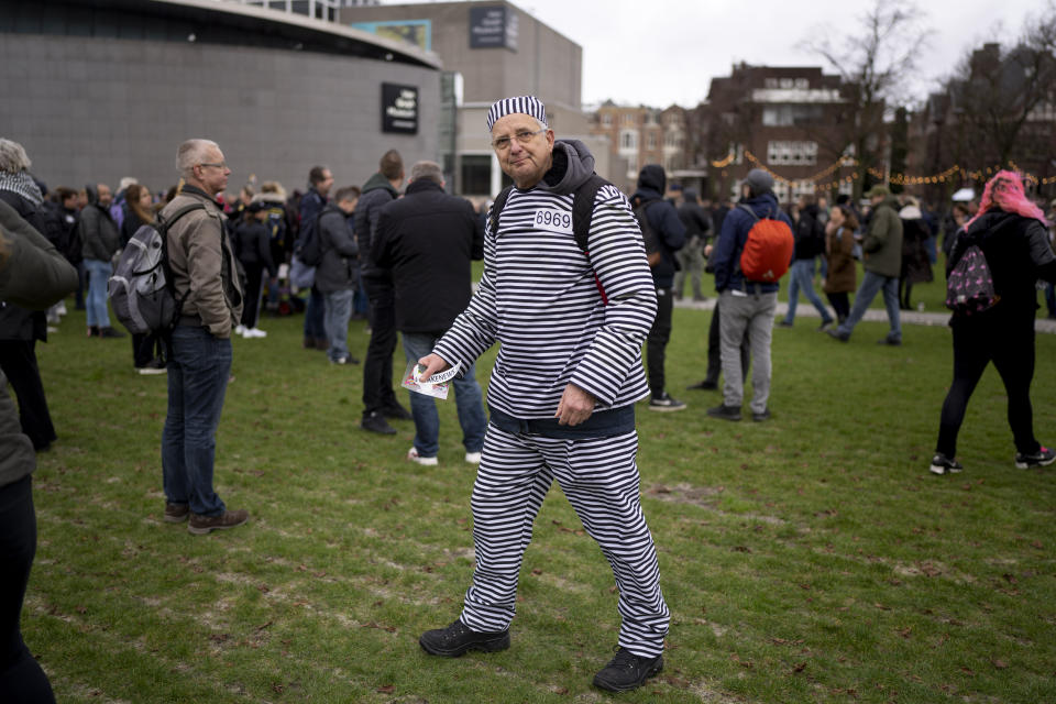 A man wearing a prisoner's suit joined hundreds of people who defied a ban Sunday to gather and protest the Dutch government's coronavirus lockdown measures, in Amsterdam, Netherlands, Sunday, Jan. 2, 2022. The municipality of the Dutch capital banned the protest, saying police had indications some demonstrators could be attending "prepared for violence." (AP Photo/Peter Dejong)