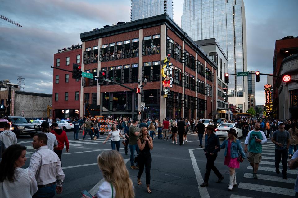 People cross Lower Broadway outside of Kid Rock’s Big Honky Tonk in Nashville, Tenn., Friday, April 28, 2023.