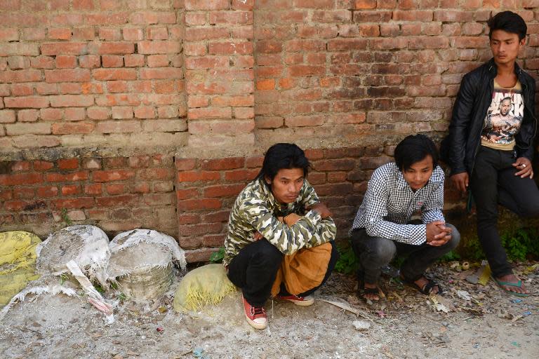 Nepalese relatives of avalanche victims wait outside a hospital morgue in Kathmandu, on October 20, 2014