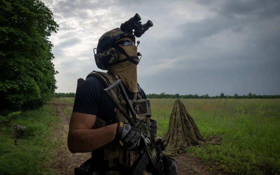 A Ukrainian soldier looks at the sky searching for a drone on the frontline in the Zaporizhzhia region