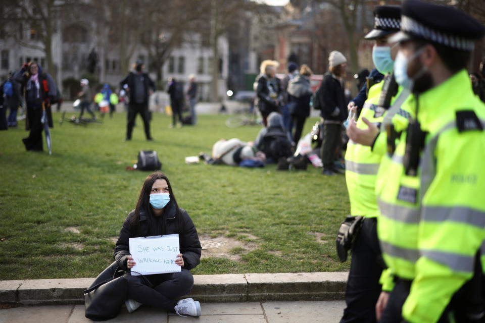 Police officers pass a demonstrator during the protest in Parliament Square, London.