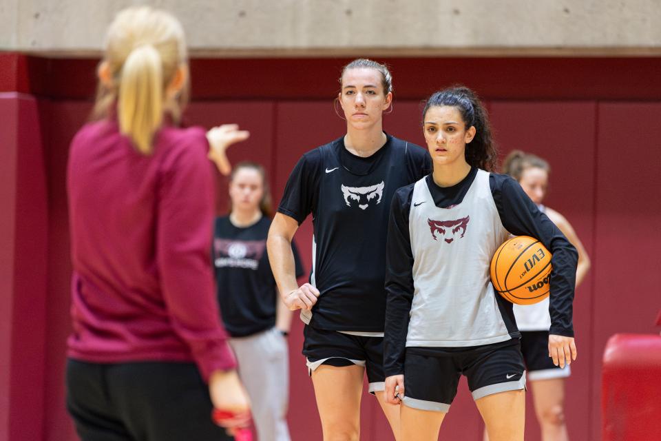 Willamette's Ava Kitchin (42) and Danielle Morgan (22) listen to their head coach, Peg Swadener, give instructions during practice at Cone Field House on Wednesday.