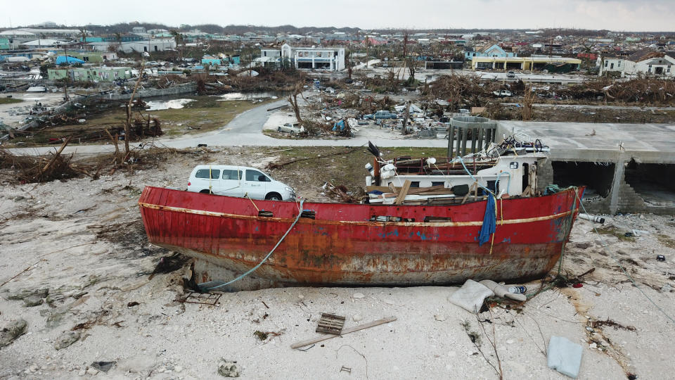 In this Sept. 6, 2019 photo, a boat sits grounded in the aftermath of Hurricane Dorian, in Marsh Harbor, Abaco Island, Bahamas. The Bahamian health ministry said helicopters and boats are on the way to help people in affected areas, though officials warned of delays because of severe flooding and limited access. (AP Photo/Gonzalo Gaudenzi)