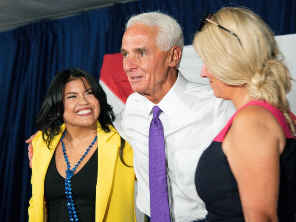 Rep. Charlie Crist, center, and his fiancé Chelsea Grimes, right, celebrate as he announces his running mate Karla Hernández-Mats, left, at Hialeah Middle School in Hialeah, Florida, on Saturday August 27, 2022.