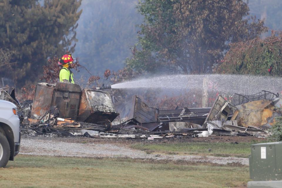 A fire official uses a hose to spray the area of an explosion after a regional gas pipeline ruptured on August 1, 2019 near Danville, Kentucky. 