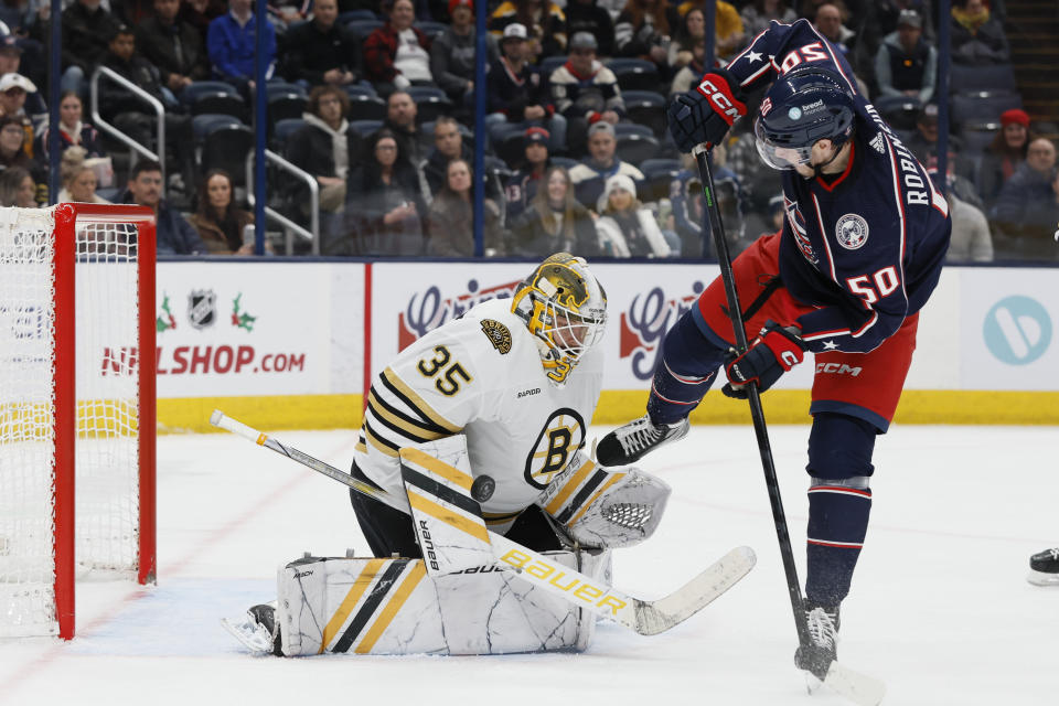 Boston Bruins' Linus Ullmark, left, makes a save against Columbus Blue Jackets' Eric Robinson, right, during the second period of an NHL hockey game Monday, Nov. 27, 2023, in Columbus, Ohio. (AP Photo/Jay LaPrete)