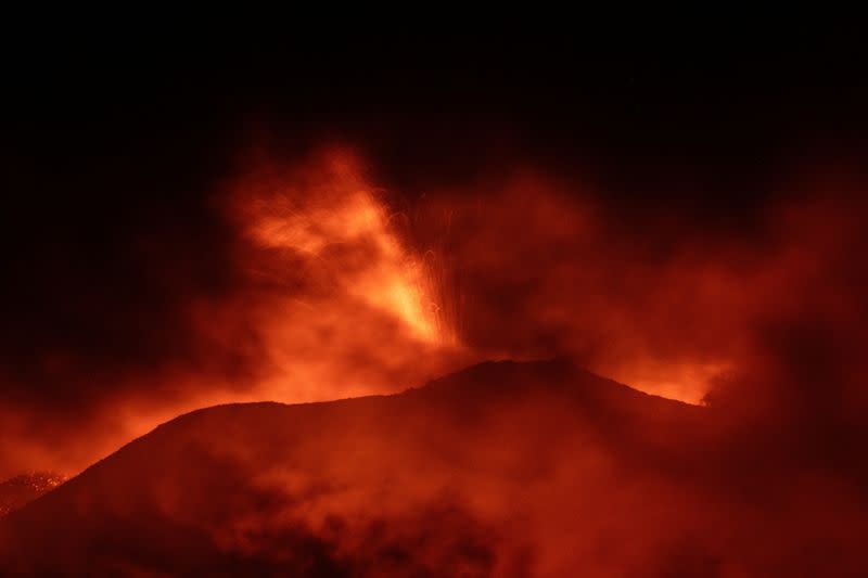 El monte Etna, el volcán más activo de Europa, ilumina el cielo nocturno con erupciones visto desde Rocca Della Valle, Italia