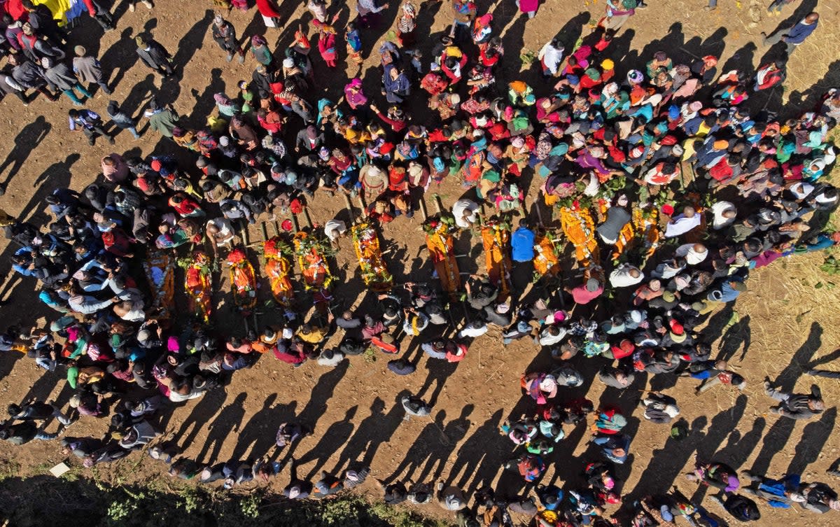 An aerial view shows family members and villagers gathered around the bodies of earthquake victims (AFP via Getty Images)