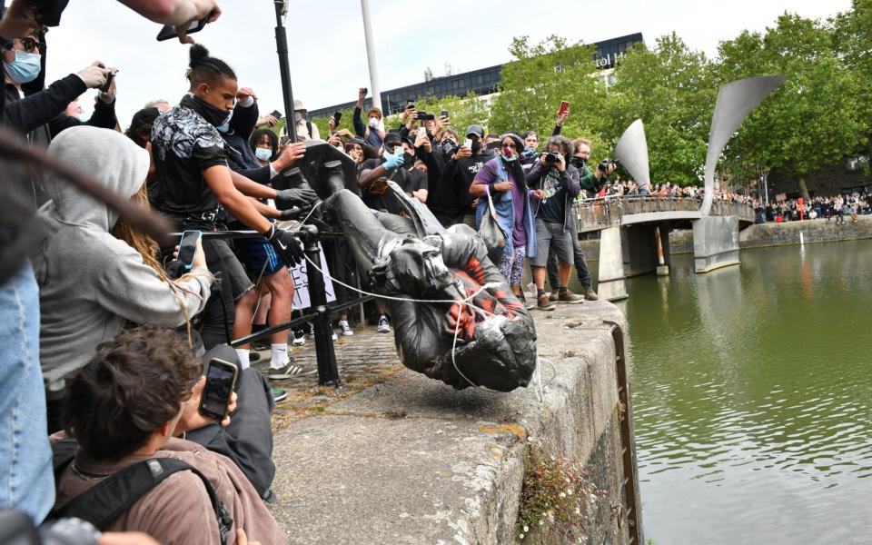 Protesters throw statue of Edward Colston into Bristol harbour during a Black Lives Matter protest rally - Ben Birchall/PA