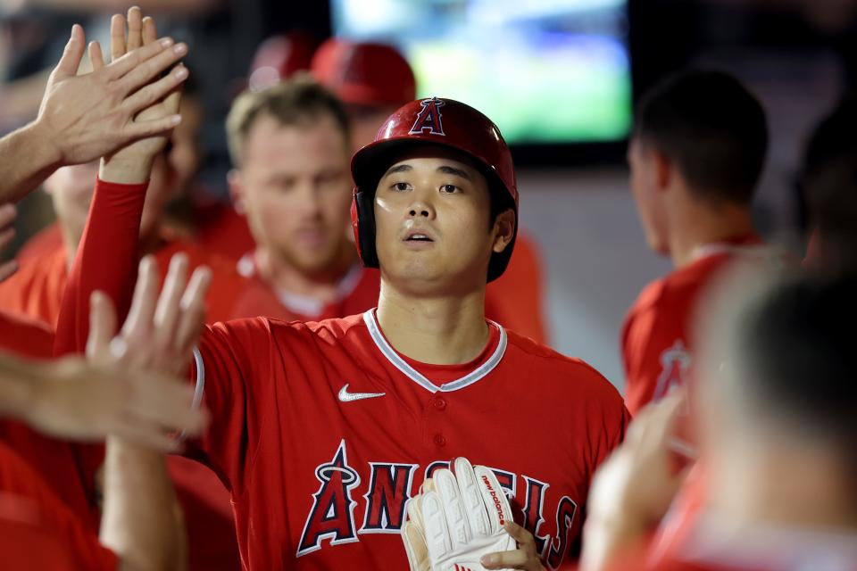 Los Angeles Angels designated hitter Shohei Ohtani (17) high fives teammates in the dugout after scoring on a single by third baseman Mike Moustakas (not pictured) during the third inning Los Angeles Angels manager Phil Nevin (88) on Aug. 25, 2023, at Citi Field.