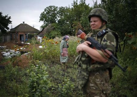 A member of the Ukrainian police special task force "Kiev-1" patrols in the eastern Ukrainian village of Semenovka near Sloviansk, July 14, 2014. REUTERS/Gleb Garanich