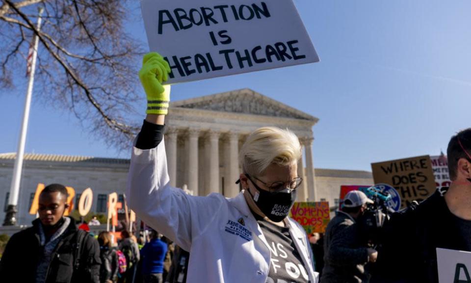 A woman holds a poster that reads &#39;Abortion is Healthcare&#39; as abortion rights advocates and anti-abortion protesters demonstrate in front of the US supreme court