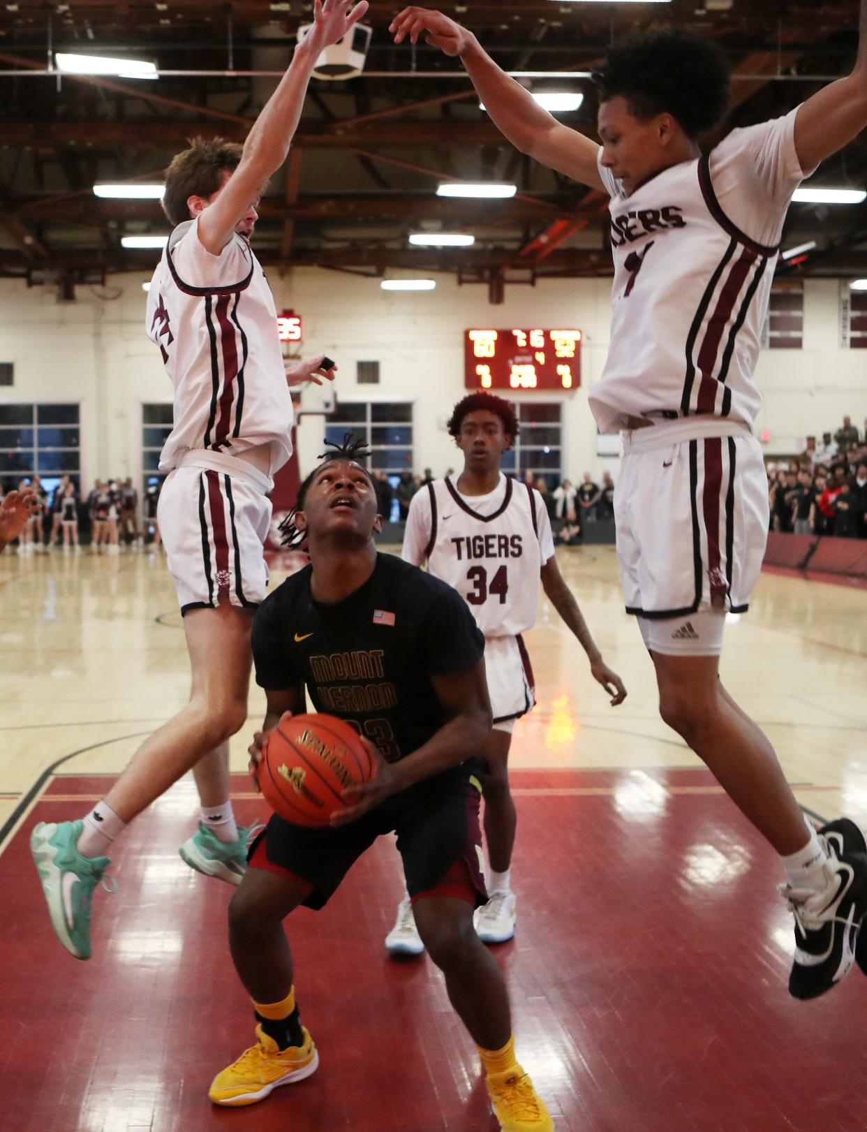 Mt. Vernon's Dwight Findlay (23) has his path to the basket blocked by Kingston's Brady Gardner (24) and Elijah Abrama (11) during the state regional final at Kingston High School March 8, 2024. Kingston won the game 81-78.