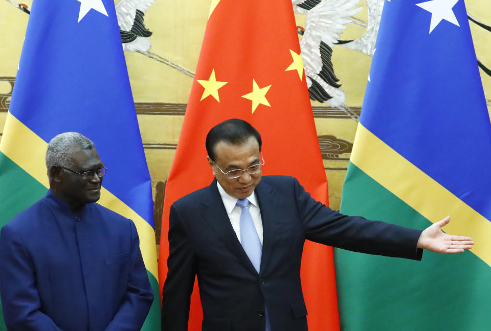 FILE - Solomon Islands Prime Minister Manasseh Sogavare, left, and Chinese Premier Li Keqiang attend a signing ceremony at the Great Hall of the People in Beijing, on Oct. 9, 2019. In an announcement Thursday, March 31, 2022, China and the Solomon Islands have signed a draft version of a security pact that could see Chinese police and other forces taking up duties in the Pacific Island nation, drawing concerns from traditional partners New Zealand, Australia and the United States. (Thomas Peter/Pool Photo via AP, File)