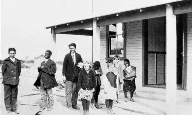 Children stand in front of a school in Lanfair Valley.