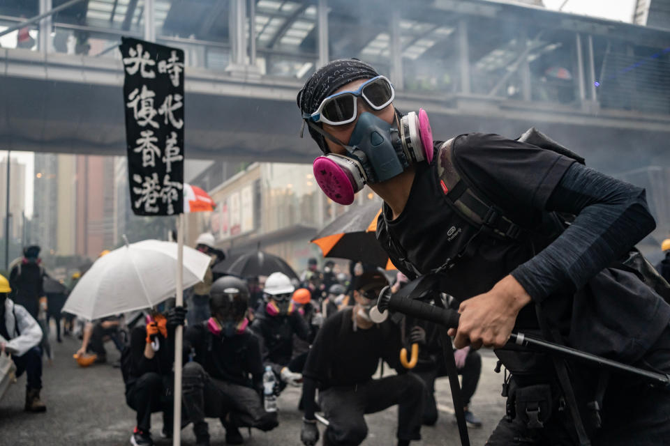 HONG KONG - AUGUST 25:  Protesters throw a brick at police during a clash at an anti-government rally in Tsuen Wan district on August 25, 2019 in Hong Kong, China. Pro-democracy protesters have continued rallies on the streets of Hong Kong against a controversial extradition bill since 9 June as the city plunged into crisis after waves of demonstrations and several violent clashes. Hong Kong's Chief Executive Carrie Lam apologized for introducing the bill and declared it "dead", however protesters have continued to draw large crowds with demands for Lam's resignation and a complete withdrawal of the bill. (Photo by Anthony Kwan/Getty Images)