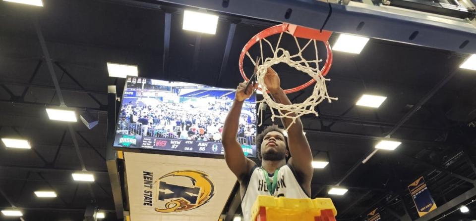 Hoban's Lamar Sperling helps cut down the net after a win over Walsh Jesuit in a Division I regional final Friday, March 10, 2023, in Kent.