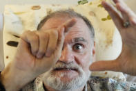 Michael Bommer, who is terminally ill with colon cancer, gestures during a meeting with The Associated Press at his home in Berlin, Germany, Wednesday, May 22, 2024. Bommer, who has only a few more weeks to live, teamed up with friend who runs the AI-powered legacy platform Eternos to "create a comprehensive, interactive AI version of himself, allowing relatives to engage with his life experiences and insights," after he has passed away. (AP Photo/Markus Schreiber)