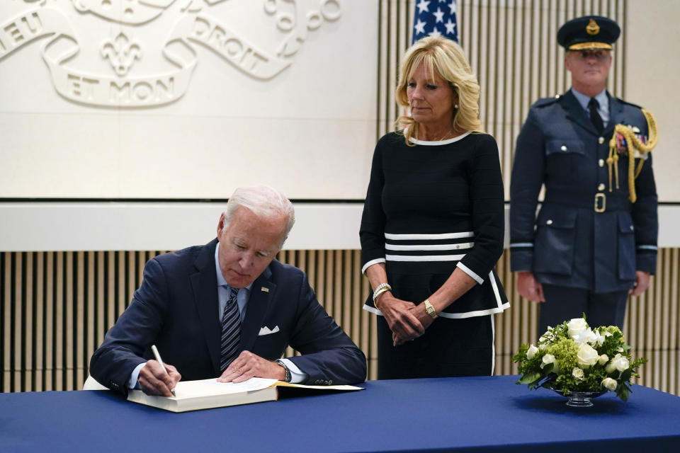 President Joe Biden signs a condolence book at the British Embassy in Washington, Thursday, Sept. 8, 2022, for Queen Elizabeth II, Britain's longest-reigning monarch and a rock of stability across much of a turbulent century, who died Thursday after 70 years on the throne. She was 96. First lady Jill Biden looks on at right. (AP Photo/Susan Walsh)