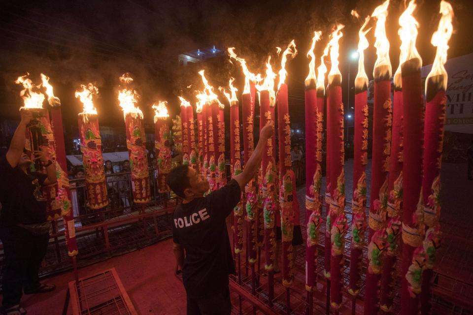 An Indonesian ethnic Chinese man lights joss sticks during the Lunar New Year celebration at a temple in Medan, North Sumatra, Indonesia, early Saturday, Feb. 10, 2024.