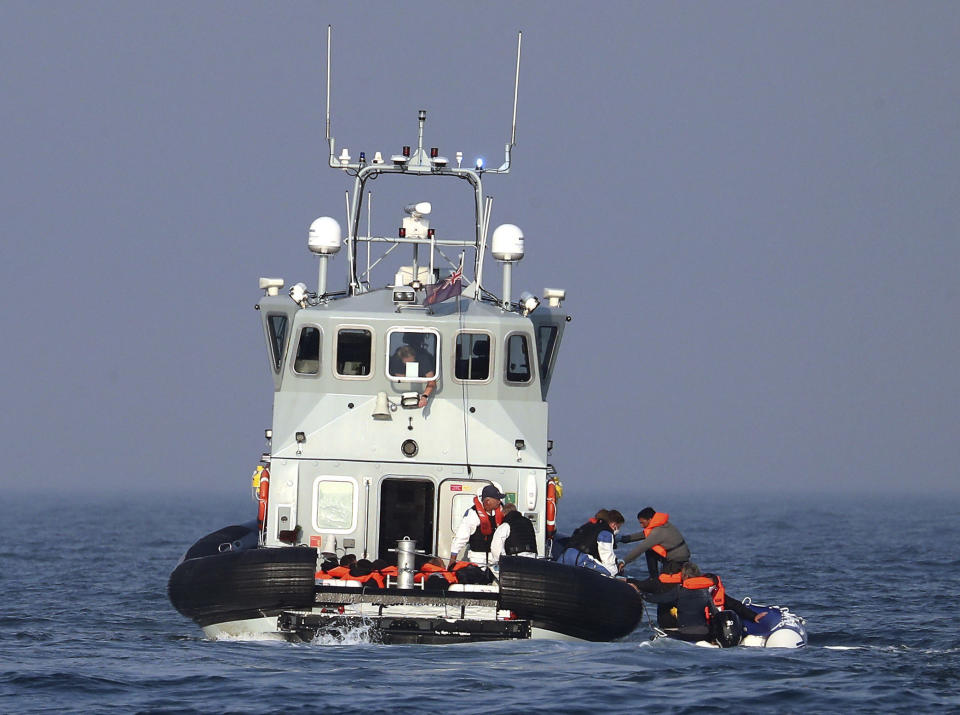 A Border Force vessel assist a group of people thought to be migrants on board from their inflatable dinghy in the Channel, Monday Aug. 10, 2020. A Royal Air Force surveillance plane is flying over the English Channel as the British government tries to curb the number of people crossing from France in small boats. Britain’s Conservative government has talked tough amid a surge in the number of migrants crossing the Channel during recent warm summer weather. (Gareth Fuller/PA via AP)