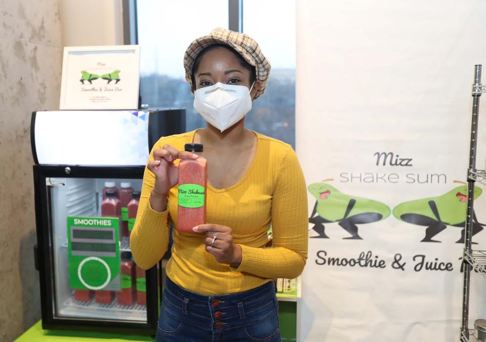 Taylor McKinnie, owner of Mizz Shakesum Smoothie & Juice Bar, holds one of her smoothies at the Northside Marketplace in Akron.