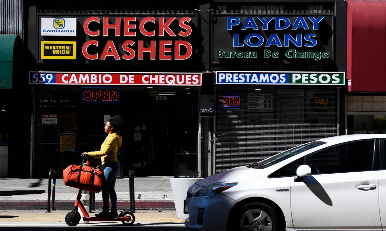 <span>A check-cashing and payday loans store in downtown Los Angeles, California, on 11 March 2022.</span><span>Photograph: Patrick T Fallon/AFP/Getty Images</span>