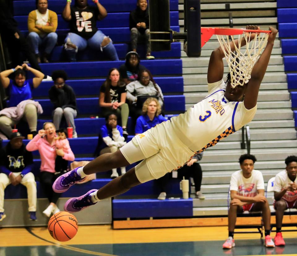 Mainland’s Narayan Thomas (3) hangs on the rim after dunking the ball against Pine Forest during the Region 1-5A boys basketball quarterfinals at Mainland High School on Thursday, Feb. 15, 2024.