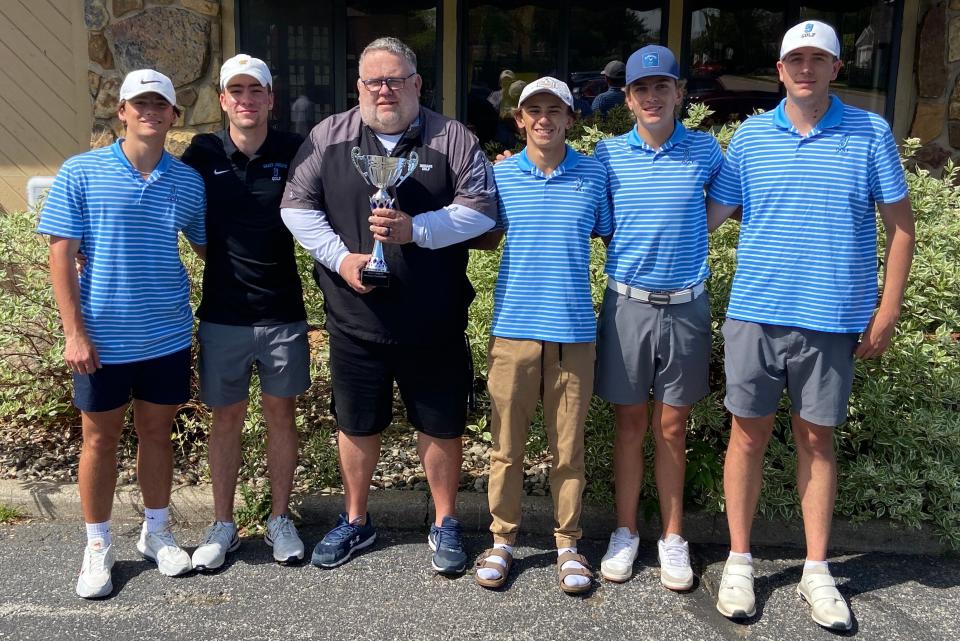 Saint Joseph boys golf team coach Bret Bajdek holds the winning trophy Friday at Eberhart-Petro Golf Course in Mishawaka after his Huskies captured the inaugural Benny Leonard Memorial Tournament. The Huskies' Blue team totaled 314 to edge Mishawaka Marian's White team by two strokes. New Prairie finished third in the tournament.