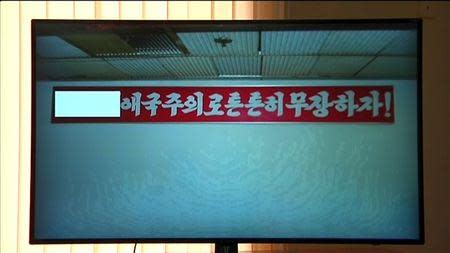 The item bearing a North Korean propaganda slogan which U.S. student Otto Warmbier was detained in January for trying to steal is seen in this still image taken from video released by North Korea's official news agency KCNA on March 16, 2016. REUTERS/KCNA via Reuters TV