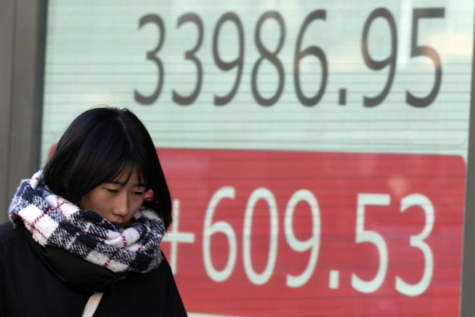 A person walks in front of an electronic stock board showing Japan's Nikkei 225 index at a securities firm Tuesday, Jan. 9, 2024, in Tokyo. (AP Photo/Eugene Hoshiko)