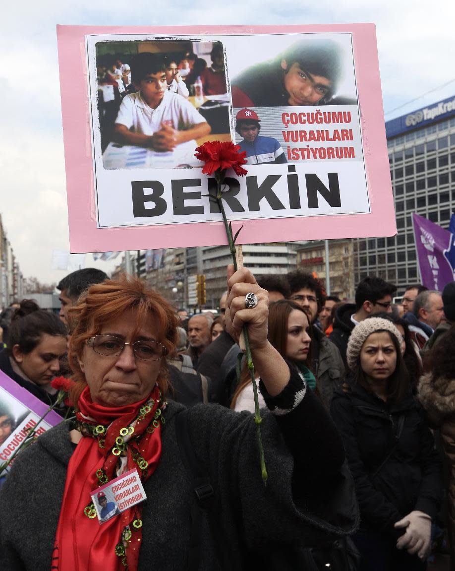 A woman holds a poster of Berkin Elvan, a Turkish teenager who has died but was was in a coma after being hit on the head by a tear gas canister fired by police during last summer's anti-government protests, during a protest in Ankara, Turkey, Wednesday, March 12, 2014. On Wednesday, thousands converged in front of a house of worship in Istanbul calling for Prime Minister Recep Tayyip Erdogan to resign. The placards read: " I want the killers of my child."(AP Photo/Burhan Ozbilici)