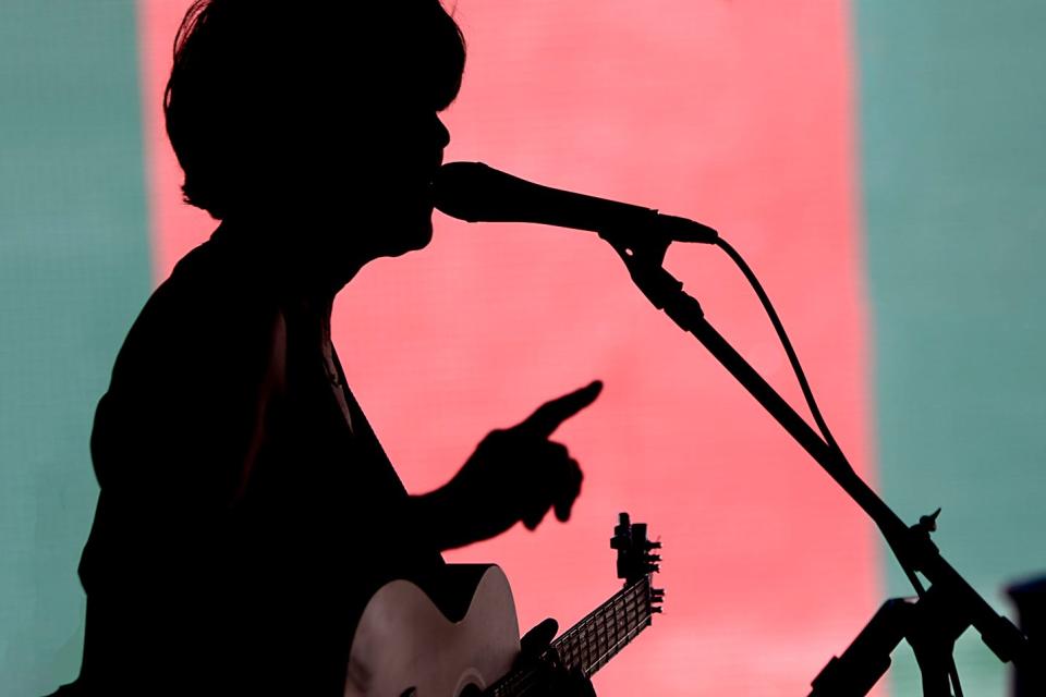 Jera & The Absolutes singer Jera Scott-Farajpanahi is silhouetted as the band performs at the Seminary Street First Friday event on Friday, June 3, 2022.