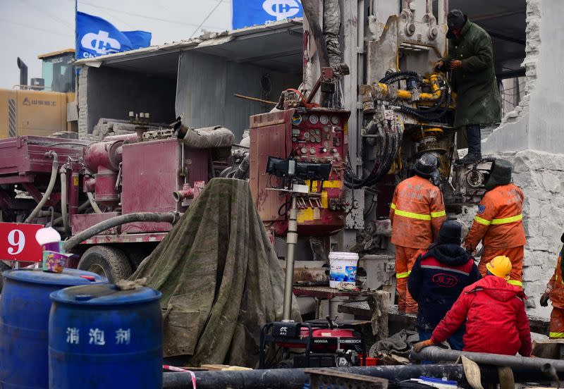 Rescuers work on saving workers trapped underground after an explosion at the Hushan gold mine in Qixia