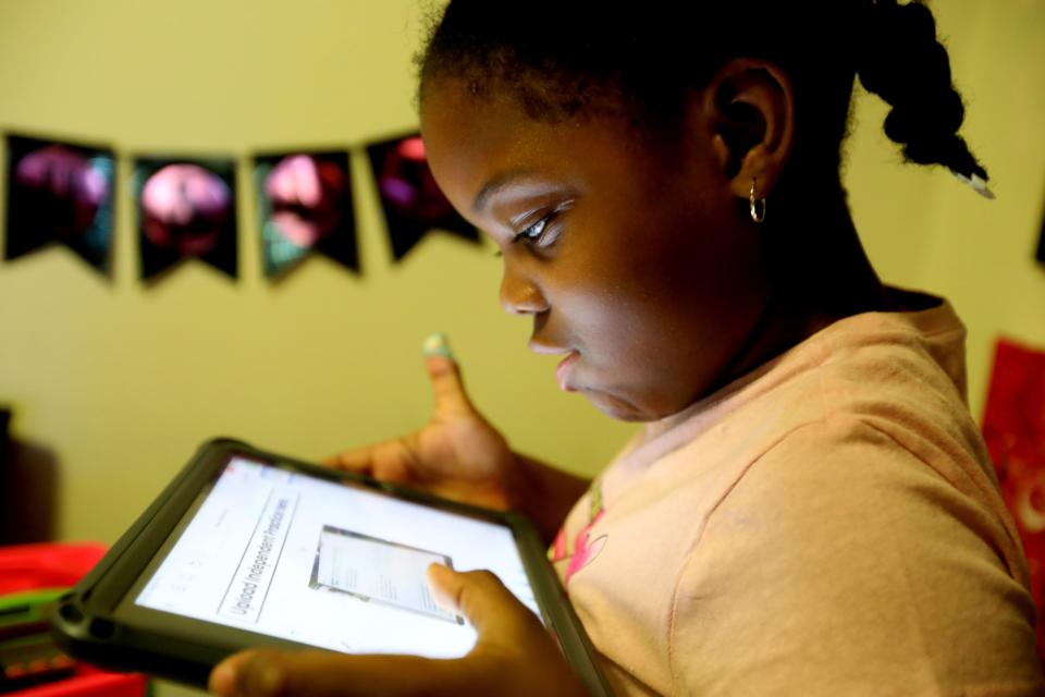 Khloe Johnson, 6, a second grader at the Mamaroneck Avenue School in White Plains, N.Y., does school works on a tablet on Oct. 14, 2020. Her mother, Nicole Johnson, who had worked for the past eight years as a teacher's aide, was forced to give up her job in order to care for Khloe, who is doing all virtual learning due to the COVID-19 pandemic.
