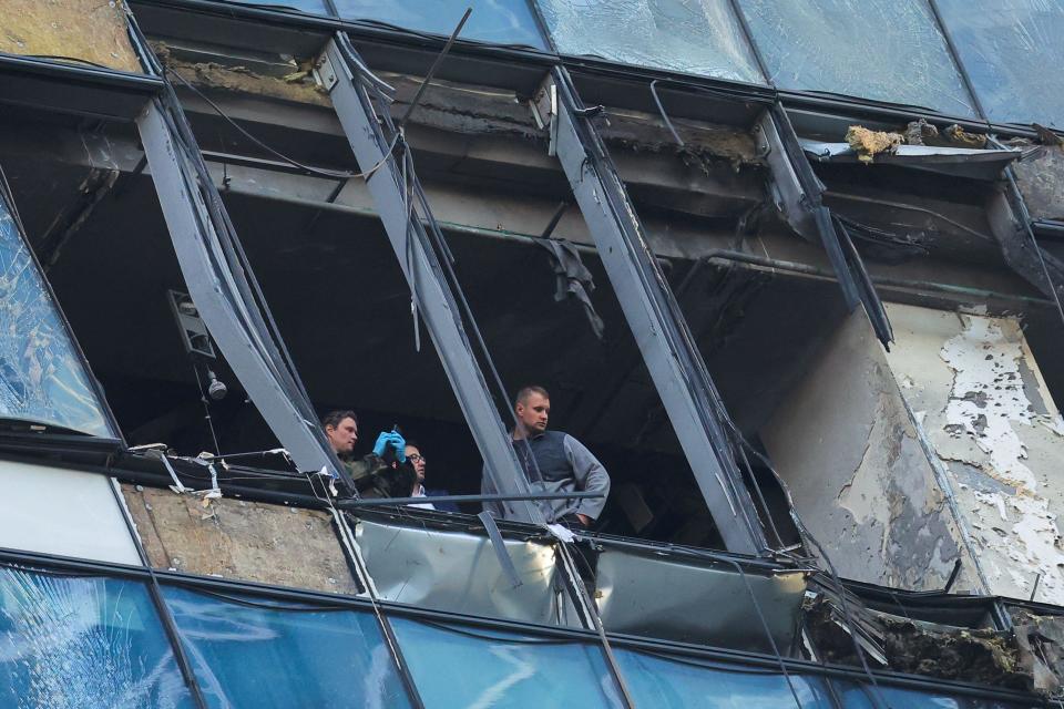 Agentes supervisan los daños infligidos por un dron en un edificio.