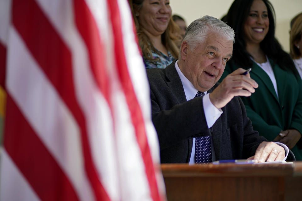 Nevada Democratic Gov. Steve Sisolak signs a bill into law Friday, June 11, 2021, in Las Vegas. The law would make Nevada the first to vote on the 2024 presidential primary contests, though national political parties would need to agree to changes in the calendar or state parties could risk losing their delegates at presidential nominating conventions. (AP Photo/John Locher)