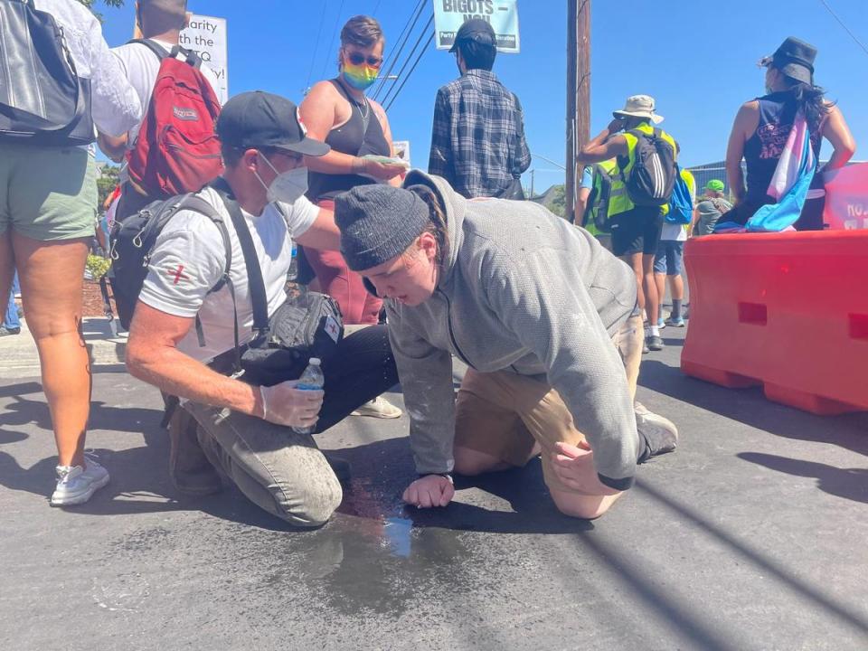 A volunteer medic washes the eyes of a young man after police fire pepper-spray bullets at counter-protesters who rallied against the “straight pride” event