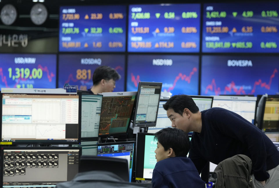 FILE - Currency traders watch monitors at the foreign exchange dealing room of the KEB Hana Bank headquarters in Seoul, South Korea, on Jan. 11, 2024. Asia markets mostly advanced Friday, Jan. 19, after Wall Street recouped most of the week's earlier losses and Japan reported slowing inflation, which may keep its ultra-low interest rates steady. (AP Photo/Ahn Young-joon, File)