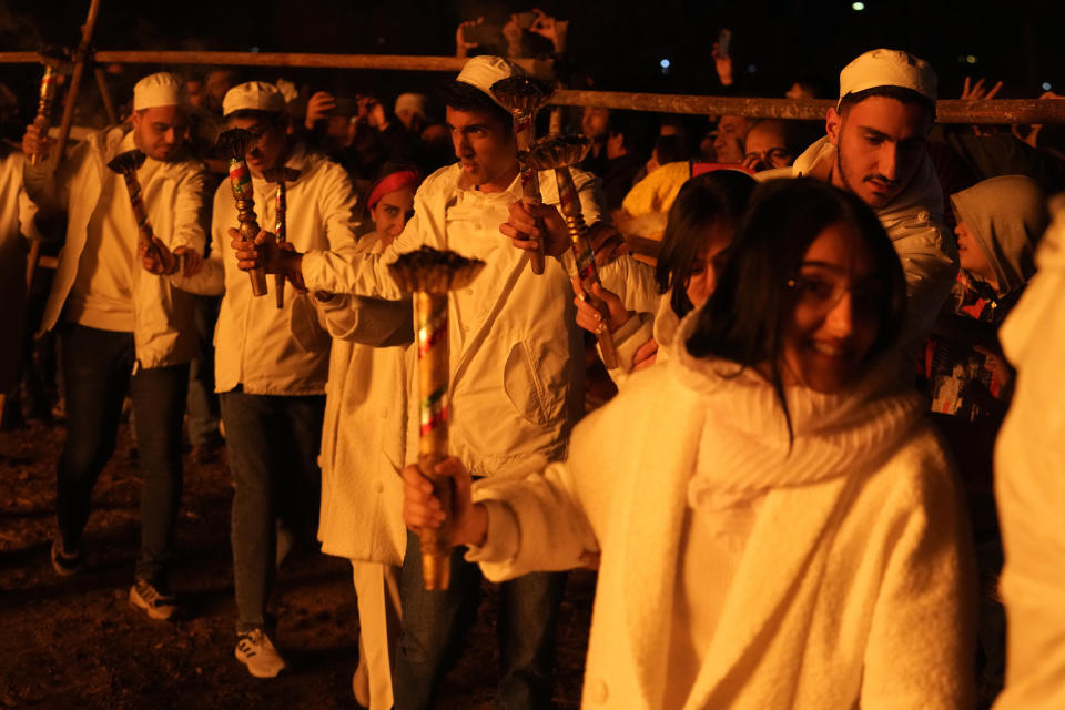 Iranian Zoroastrian youth join hands after setting a prepared pile of wood on fire as they celebrate their ancient mid-winter Sadeh festival in outskirts of Tehran, Iran, Tuesday, Jan. 30, 2024. Hundreds of Zoroastrian minorities gathered after sunset to mark their ancient feast, creation of fire, dating back to Iran's pre-Islamic past. (AP Photo/Vahid Salemi)