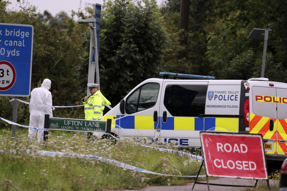 A police investigator at the scene of an incident where a police officer was killed, near Sulhamstead, England, Friday, Aug. 16, 2019. Thames Valley police say a British police officer investigating a reported burglary has been killed. Ten males have been arrested and are in custody, including a 13-year-old. Authorities say police Constable Andrew Harper of the Roads Policing Proactive unit was killed while "performing his duties" on Thursday night near the A4 between Reading and Newbury, in southeast England. (Steve Parsons/PA via AP)