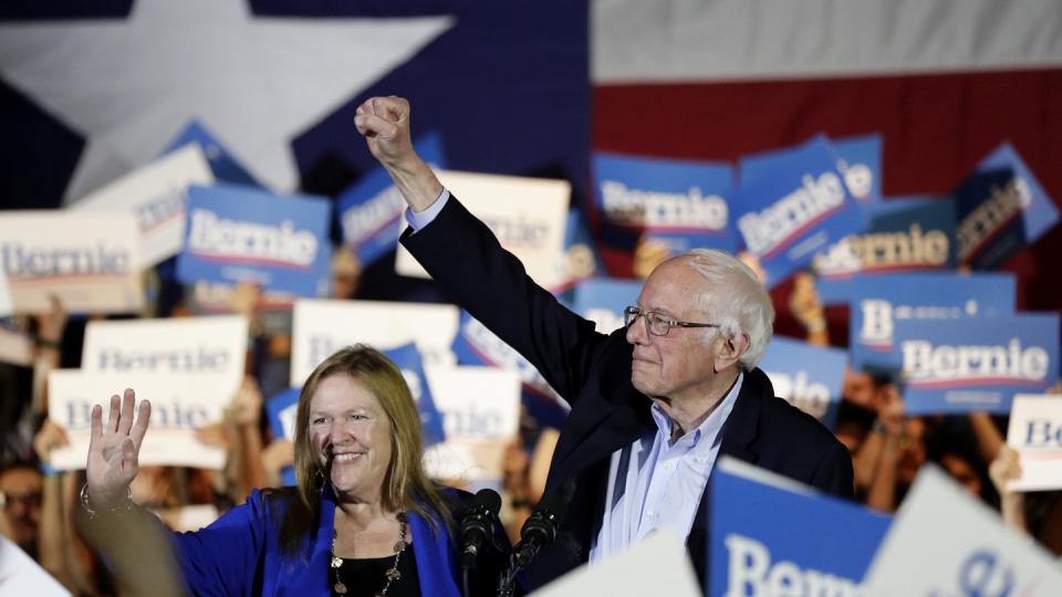 Bernie Sanders und seine Frau Jane stehen bei einer Wahlkampfveranstaltung inmitten von Anhängern.